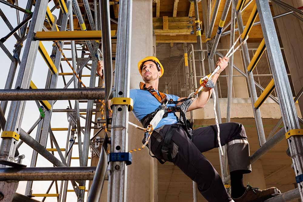 Arbeiter mit Helm und Sicherung gegen Absturz