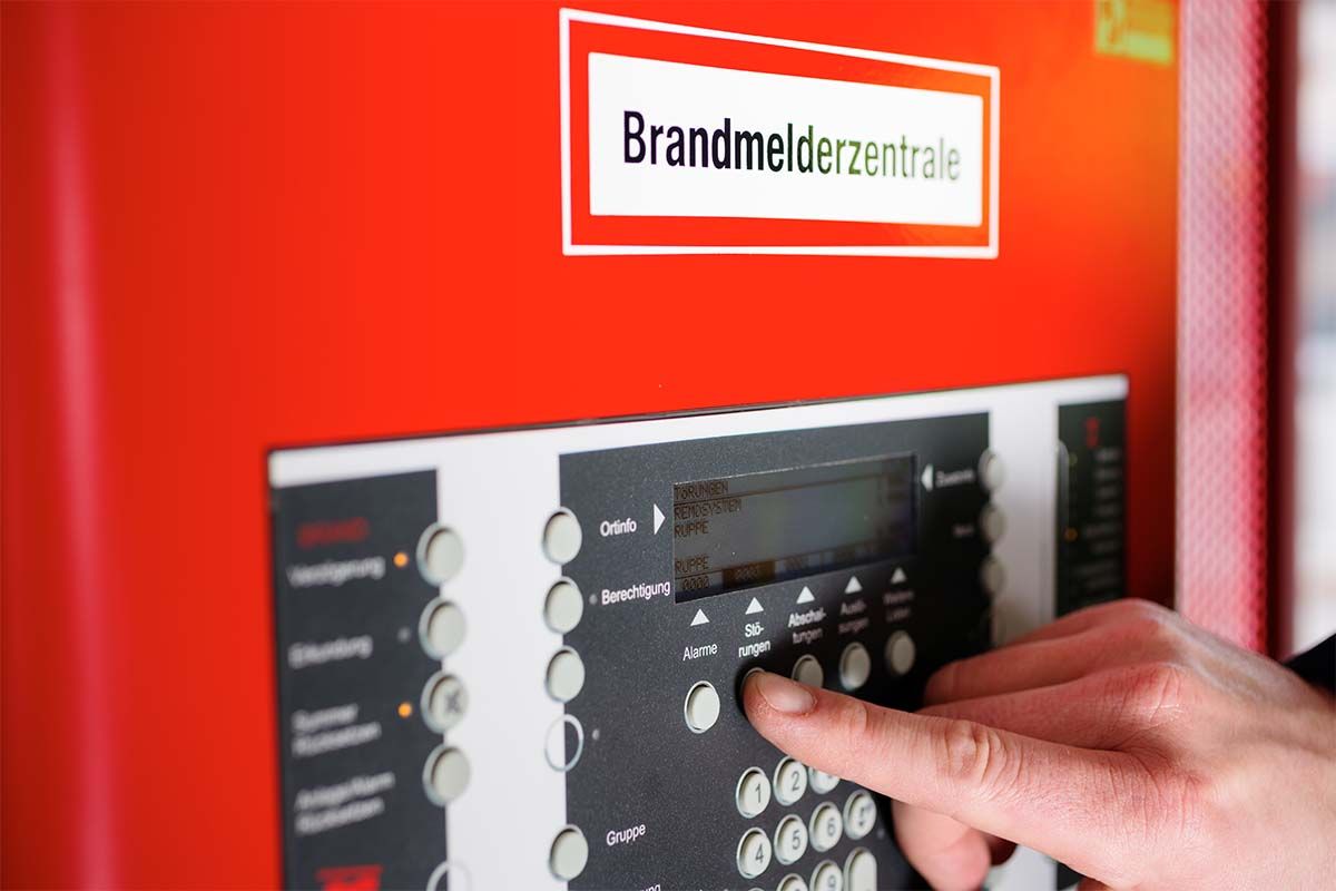 Hand, die eine Brandmeldezentrale benutzt